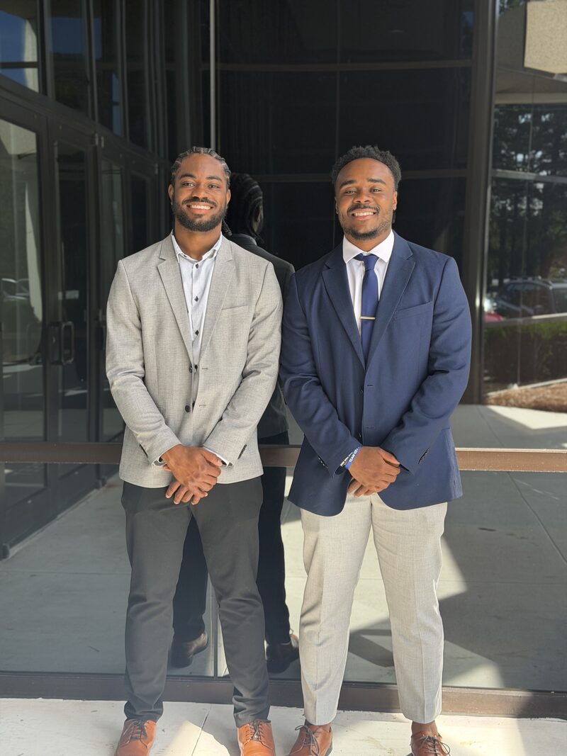 Two Noble Impact Marketing team members in business attire outside an office