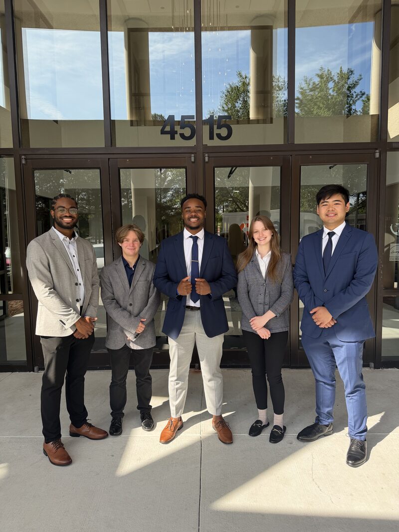 Five young Noble Impact Marketing professionals smiling in business attire